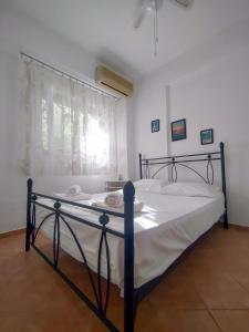 a bedroom with a bed with white sheets and a window at O&A Kallithea in Kallithea Halkidikis