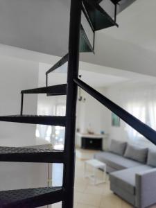 a spiral staircase in a living room with a couch at O&A Kallithea in Kallithea Halkidikis