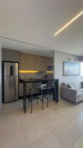 a kitchen and living room with a table and a couch at Apto 31º andar, 4km do centro, colado ao Umarizal in Belém