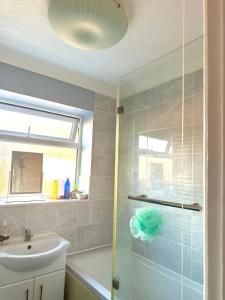 a bathroom with a sink and a glass shower door at 40 Kennett gardens in Gloucester +4 photos
