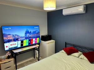 a bedroom with a bed and a flat screen tv at 40 Kennett gardens in Gloucester