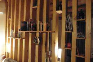 a wall with wooden bookshelves in a room at la Loge à SANSSAC in Sanssac-lʼÉglise