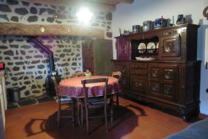 a dining room with a table and a wooden cabinet at la Loge à SANSSAC in Sanssac-lʼÉglise