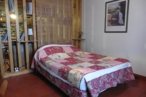 a bedroom with a bed with a quilt on it at la Loge à SANSSAC in Sanssac-lʼÉglise