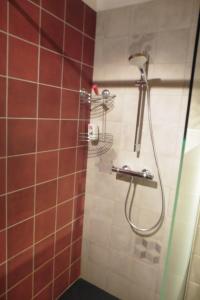 a bathroom with a shower with red and white tiles at la Loge à SANSSAC in Sanssac-lʼÉglise +7 photos