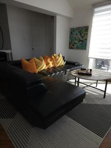 ein Wohnzimmer mit zwei schwarzen Sofas und einem Tisch in der Unterkunft Condo ÉVASION in Magog-Orford
