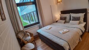 a bedroom with a bed and a large window at Waldherberge Sargenroth in Sargenroth