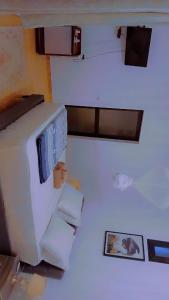 a room with a white refrigerator and some towels at Chez Fatima et Hervé in Somone