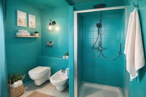 a blue bathroom with a shower and a toilet at SicilyNice in Avola +29 photos