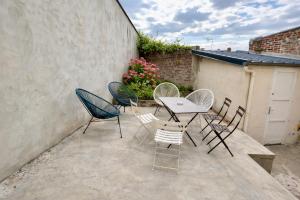 a group of chairs and a table on a patio at La Coloc Boho - Saint-Quentin, chambres centre, idéal pro in Saint-Quentin