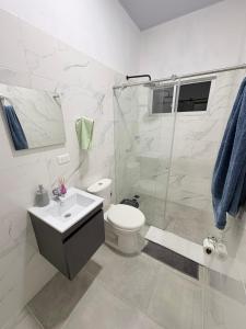 a bathroom with a shower and a toilet and a sink at Casa WHITE in Melgar +53 photos