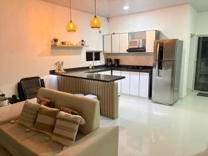 a living room with a couch and a kitchen at Casa WHITE in Melgar