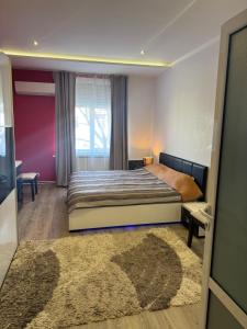 a bedroom with a bed and a window and a rug at Apartamento Elit in Dimitrovgrad