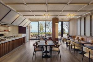a restaurant with tables and chairs and a kitchen at Sheraton Suzhou Yangcheng Lake in Suzhou