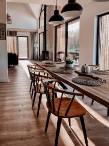a dining room with a long wooden table and chairs at TATANKA Dom Wakacyjny z sauną i balią z jacuzzi in Białowieża