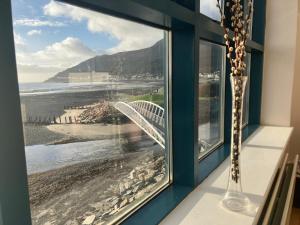a room with a window with a view of the beach at John's Luxury Seafront Apartment in Newcastle