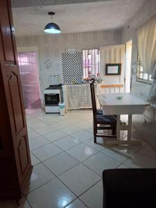 a kitchen with a white table and a table and a table and chairs at Meu Aconchego in Embu