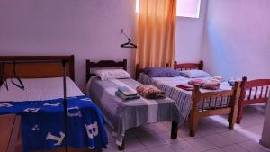 a bedroom with two beds and a table and chairs at Meu Aconchego in Embu