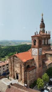 an old brick building with a clock tower at Ca Rolina in Camagna Monferrato