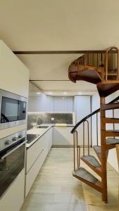 a kitchen with a spiral staircase leading to a loft at Ca Rolina in Camagna Monferrato