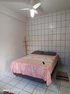 a bedroom with a bed with a pink blanket at LAR DE PRAIA - Suíte in Serra