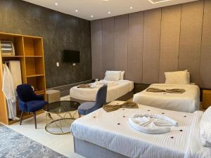 a hotel room with three beds and a table and chairs at Glow Pyramids View Hotel in Cairo