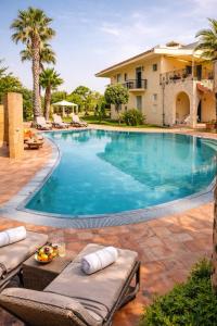 a large swimming pool with chairs and a house at SicilyNice in Avola