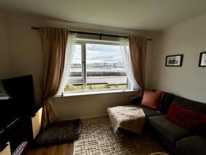 a living room with a couch and a large window at Newton Marina View in Stornoway