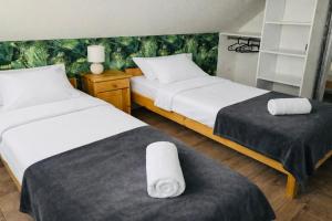 two beds in a hotel room with towels on them at Domek pod lasem in Pogorzelica