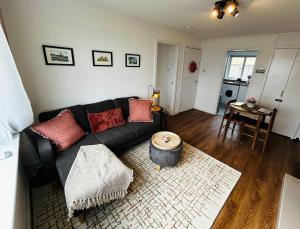 a living room with a black couch and a table at Newton Marina View in Stornoway +12 photos