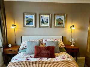 a bedroom with a bed with three pictures on the wall at Newton Marina View in Stornoway