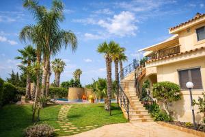 a house with palm trees and a stairway at SicilyNice in Avola
