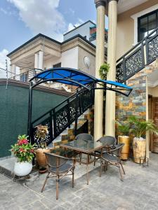 a patio with a table and chairs in front of a building at Afia Cottage Inn in Ayaso