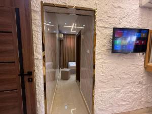 a mirror in a room with a television on a wall at Glow Pyramids View Hotel in Cairo