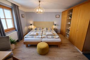 a bedroom with a large bed with a yellow ottoman at Toms ONE in Saalfelden am Steinernen Meer
