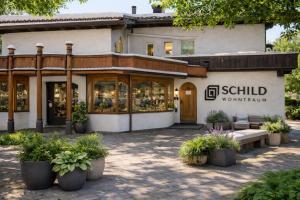 a store front of a building with plants in front at Toms ONE in Saalfelden am Steinernen Meer