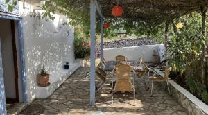 a patio with a table and chairs under a pergola at Maison bord de mer in Risika