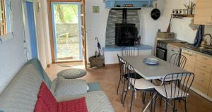 a kitchen with a table and chairs in a kitchen at Maison bord de mer in Risika