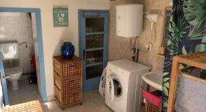 a bathroom with a washing machine and a sink at Maison bord de mer in Risika