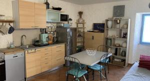 a kitchen with a table and chairs and a refrigerator at Maison bord de mer in Risika +17 photos
