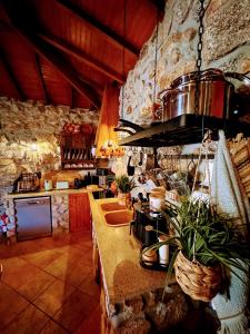 a large kitchen with a stone wall at Casa do Monte Sereno in Celorico de Basto