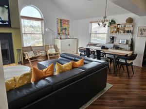 ein Wohnzimmer mit schwarzem Ledersofa und ein Esszimmer in der Unterkunft Condo ÉVASION in Magog-Orford + 28 Fotos