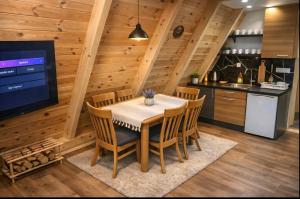 a kitchen and dining room with a table and a tv at Spa villas Higo in Žabljak