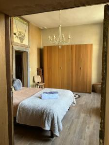 a bedroom with a large bed and a chandelier at Gîte La Cure in Noduwez