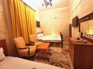 a bedroom with a bed and a chair and a desk at Emka historic biutuque stone house in Urfa