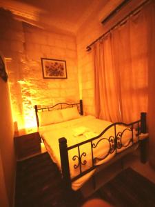 a bedroom with a black bed with a window at Emka historic biutuque stone house in Urfa