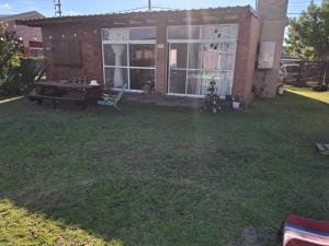 a backyard with a ping pong table in front of a house at Nuestro refugio in Roldán