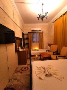a room with two beds and a living room at Emka historic biutuque stone house in Urfa