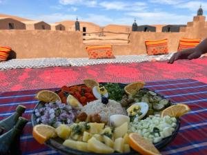 a plate of food on a table in the desert at Tarrast Desert Camp in Mhamid