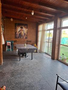 a room with a ping pong table and a painting on the wall at Nuestro refugio in Roldán